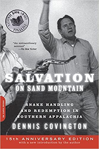 Cover of Salvation on Sand Mountain showing a man, hand raised in worship, while another man holds a large snake before him.