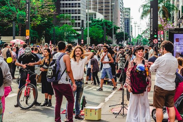 A snapshot of a crowd of people moving across a city street.